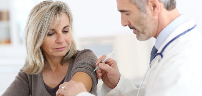 Doctor giving flu shot to patient
