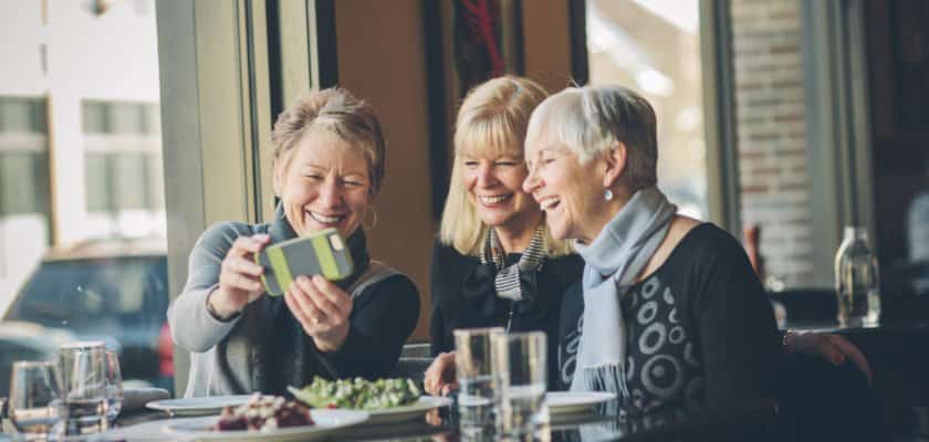 Group of older women looking at cellphone