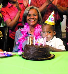 Mature woman blowing out candles for her birthday.