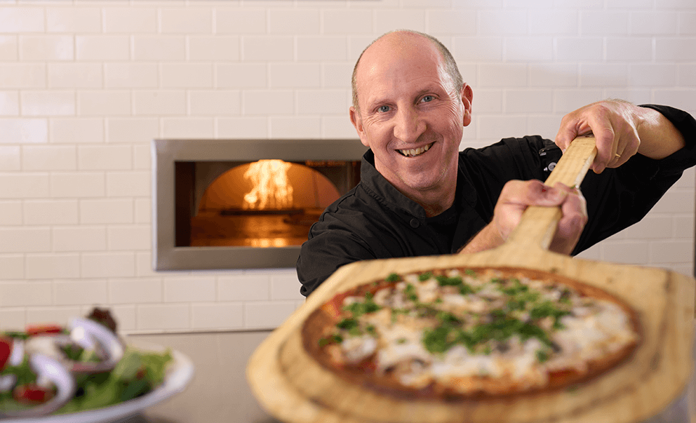 chef with pizza right out of the oven