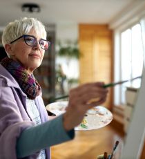 Senior woman enjoying while painting at home.