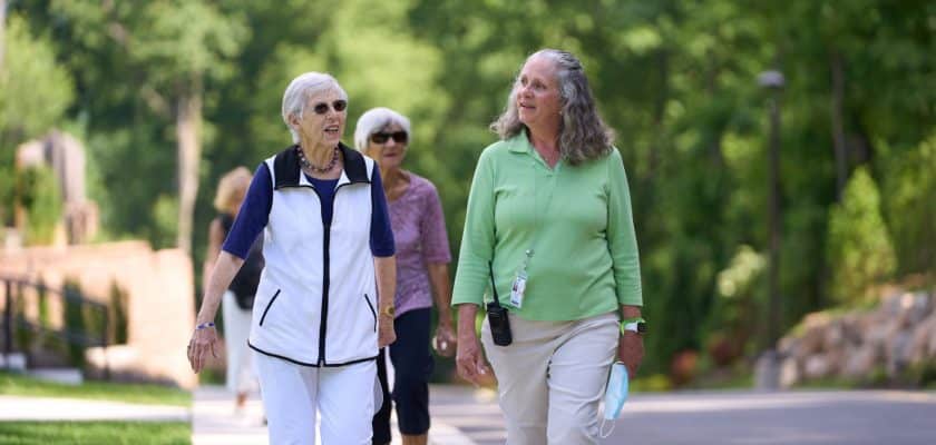 3 woman outside walking down sidewalk