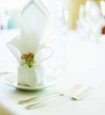Table set with napkin and cutlery, close-up.
