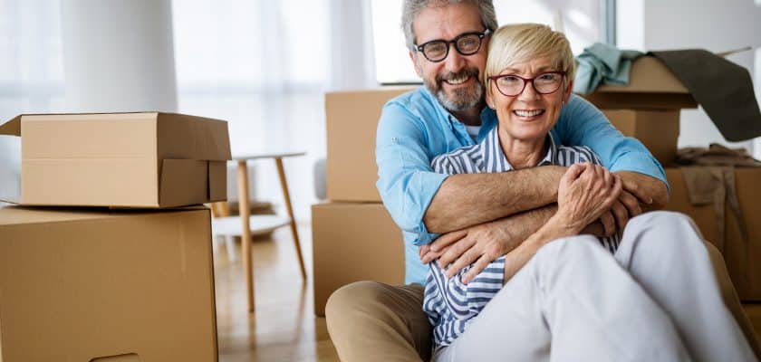 a couple sitting on floor with moving boxes